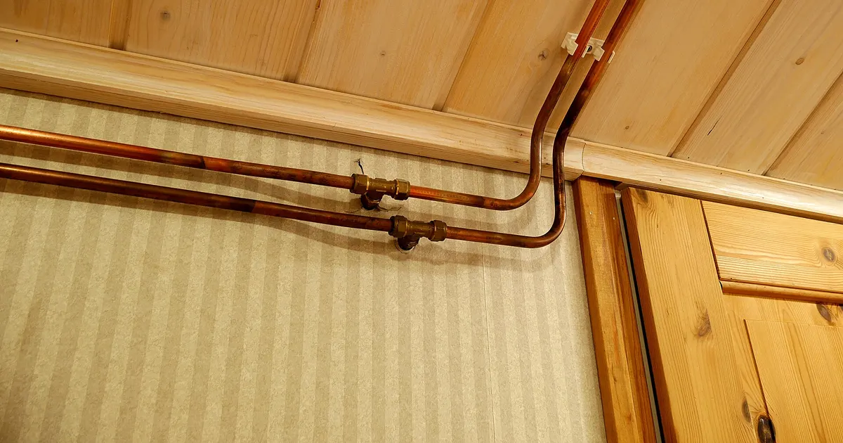 Copper water pipes along a wall and ceiling, the product form in which C12200 phosphorus deoxidized copper is most common